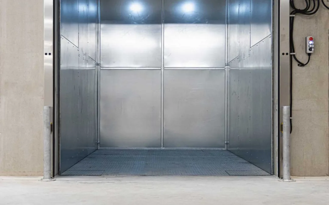 Hydraulische goederenlift in een betonschacht met geopende deuren