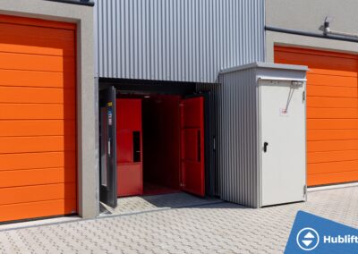 Goederenlift bij self storage Speicher Box met geopende buitendeur en rode binnendeuren