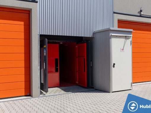 Industriële goederenlift met zelfdragende schacht en rood platform, deuren open