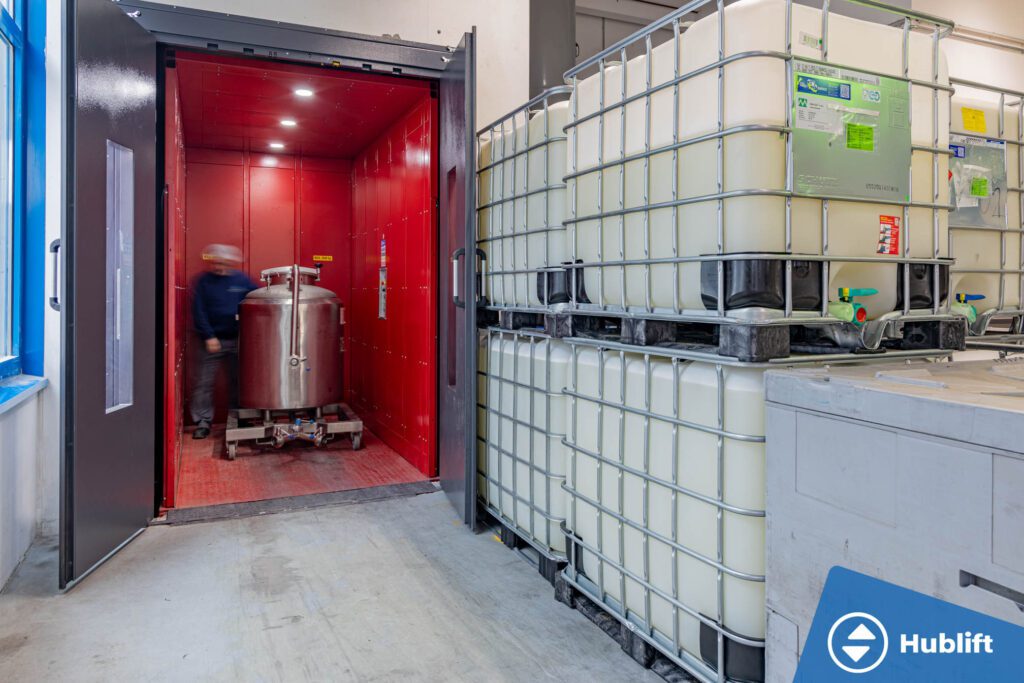 IBC-container in de goederenlift voor verticaal transport tussen verdiepingen