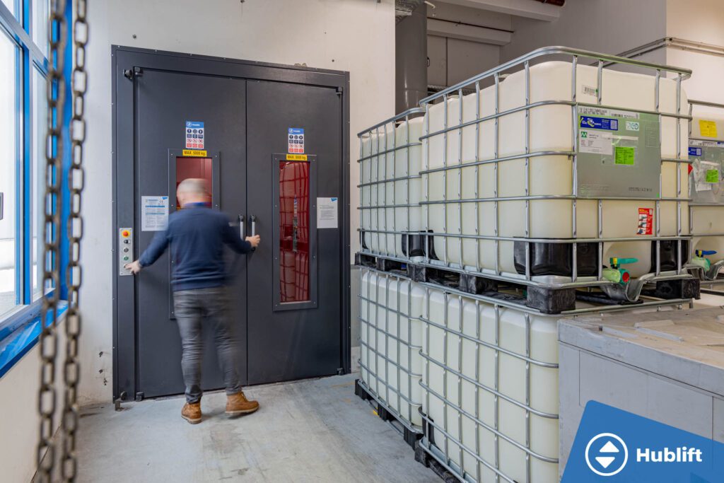 Medewerker stapt in een goederenlift met persoonsbegeleiding