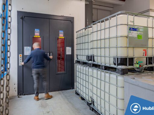 Industriële goederenlift met zelfdragende schacht en rood platform, deuren open