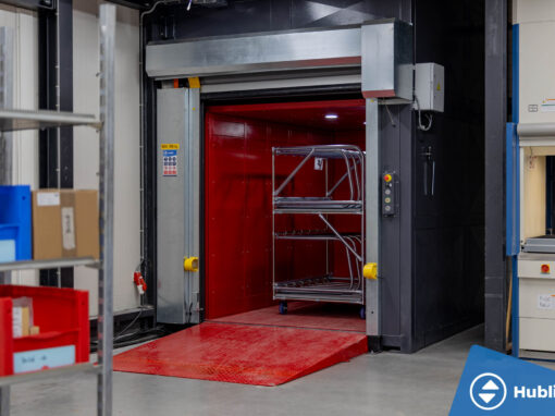 Industriële goederenlift met zelfdragende schacht en rood platform, deuren open
