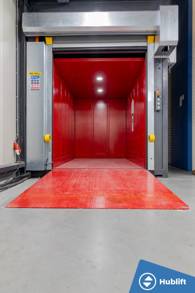 Red car of the goods lift with LED lighting and loading ramp