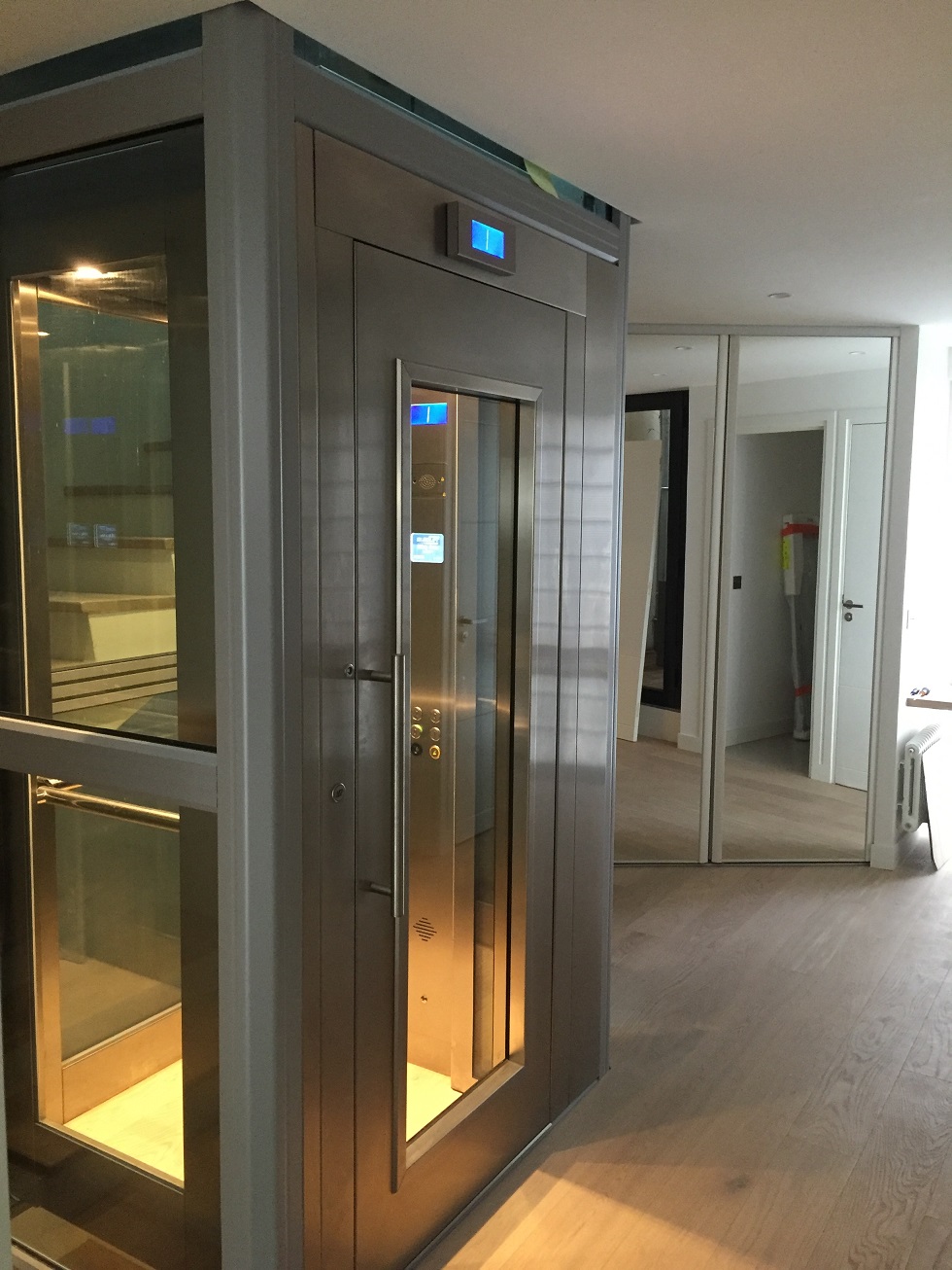 Home lift with a wooden frame and glass doors in a house