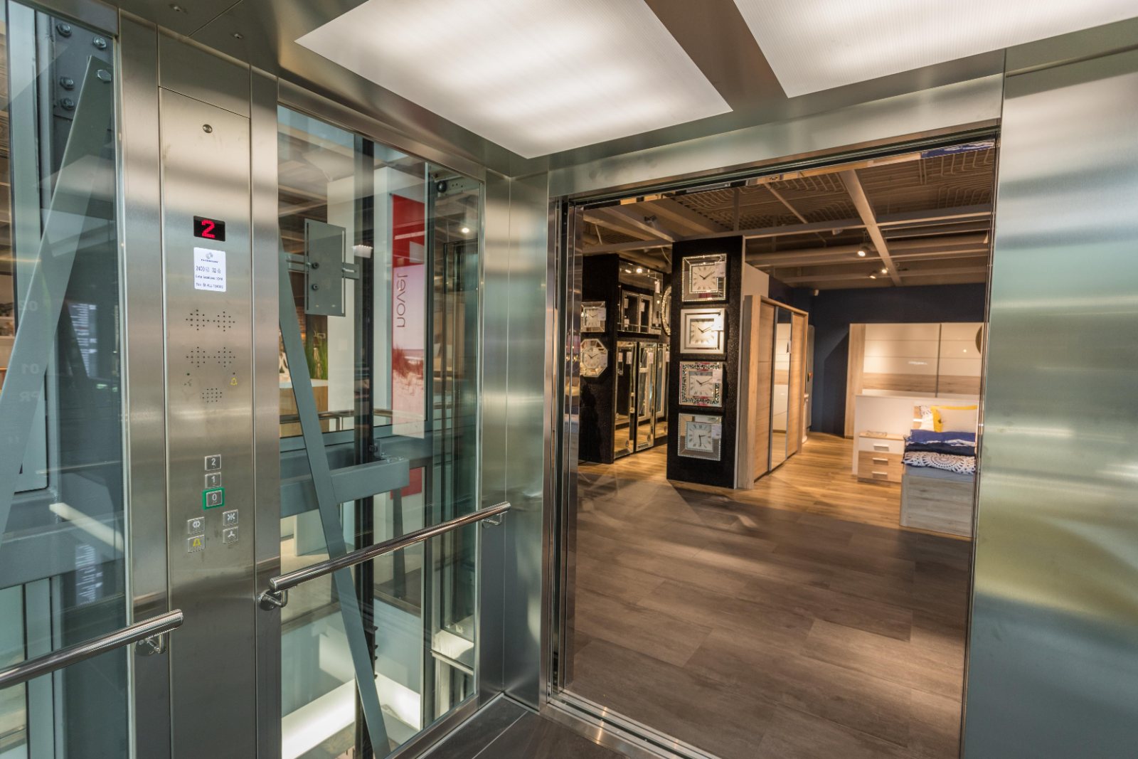 Personenlift met glazen cabine in een showroom Personenlift met glazen cabine in een showroom