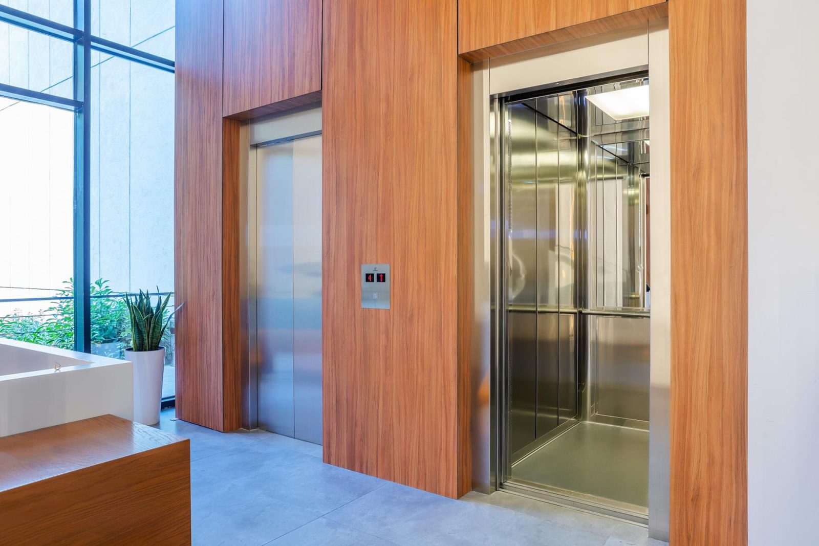 Personenlift met houten wandafwerking in een kantoorentree
